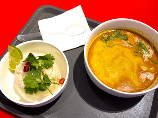 Tom yam soup on a tray on a red background