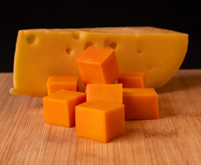 Orange cheese cut into cubes, close-up view.
