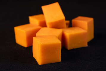 Orange cheese cut into cubes, close-up view.