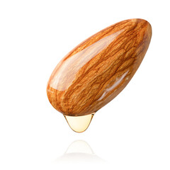 one almond nut with falling drop of oil on white isolated background