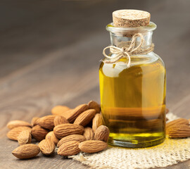 almond oil in a bottle and fresh almonds on the table