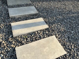 Rectangle stepping stones with gravel stone pebbles floor leading towards building entrance