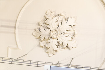 Round antique vintage decorative clay stucco relief molding with floral ornaments on white ceiling in abstract classical style interior