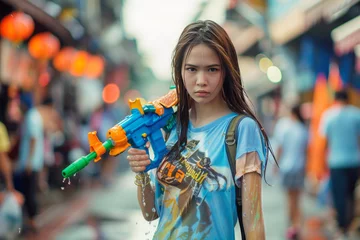 Foto op Plexiglas Traveler asian woman wearing summer shirt holding colourful squirt water gun over blur city, Water festival holiday concept © grapestock
