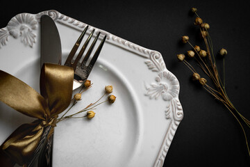 Romantic tabble setting with ribbon, plates, cutlery on black background. Empty plate. Mockup...
