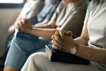 Group of Christian women sat together in chairs, holding their Bibles, feeling the togetherness of prayer and their religious connection to God. Group christian pray concept.