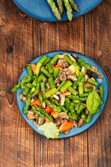 Asparagus and mushroom salad on a wooden table. - 784324917