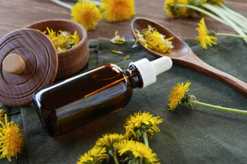 Small glass bottle of dandelions tincture(water infusion, extract, perfume). Dandelion essential oil. Fragrant flower for perfumery, cosmetics production. Side view, copy space for text, product place - Powered by Adobe