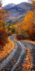 Winding road in autumn, close up, leaves in foreground, mountains ahead 