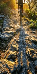 Fototapeta na wymiar Biker's shadow on rocky trail, close up, sunrise, dynamic angle 