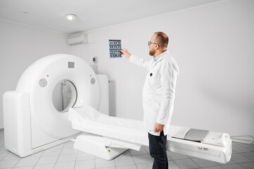 Doctor with medical computed tomography or MRI scanner. Radiologist holding and examining results...