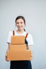 woman start up small business owner writing address on cardboard box at workplace.small business entrepreneur SME or freelance asian woman working with box at home.