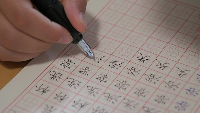 An Asian child is writing Chinese characters