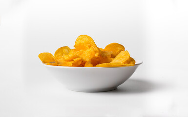 A bowl of chips is sitting on a white background. The chips are yellow and appear to be crunchy