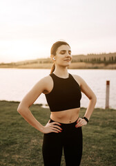 A young woman in sportswear does fitness exercises at sunset in nature. Healthy lifestyle concept. Fitness and sport