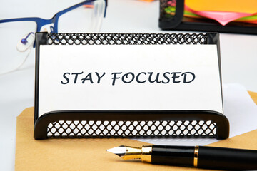 Motivation concept. STAY FOCUSED written on a business card on the table
