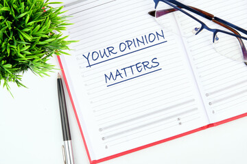 YOUR OPINION MATTERS phrase written in a notebook on the table