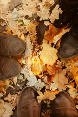 Crop people standing on autumn leaves