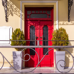 A classic design house entrance with a bright red door. Travel to Athens, Greece. - 784341998