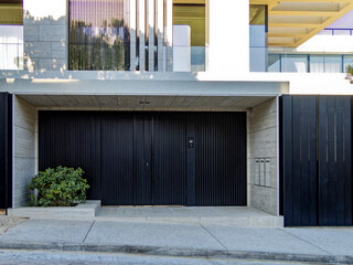 A modern design residential building front and entrance with a black painted iron door at the posh suburbs of Athens. Travel in Greece. - 784342335