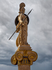 Athena Greek goddess statue, as a woman warrior with helmet, shield and spear under a stormy sky. Travel to Athens, Greece. - 784342520