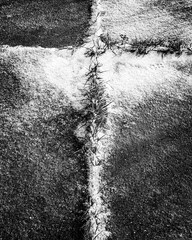 Vertical shot of a field divided by grass into four parts covered in snow