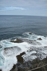 Beautiful landscape of waves crushing stones on a gloomy day