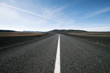 Beautiful view of an empty asphalt road under blue cloudy sky - obrazy, fototapety, plakaty
