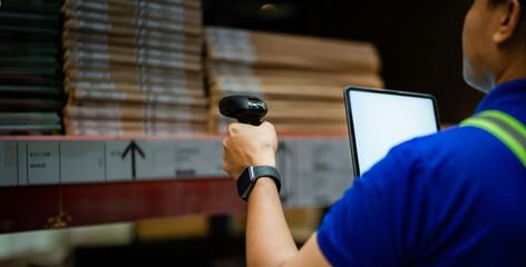 A man in a blue shirt is using a barcode scanner to scan items in a warehouse. Concept of efficiency and organization, as the man is focused on his task and using technology to complete it