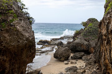 Large rock formations on sandy beach with blue sea in the background in Puerto Rico - Powered by Adobe