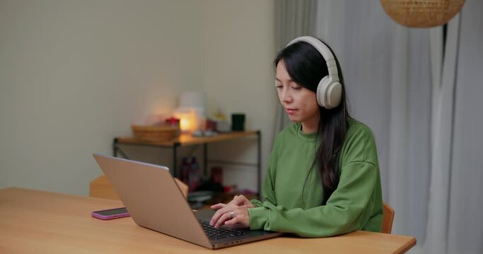Woman study on the laptop computer with headphone at home