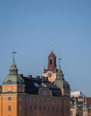 Fototapeta na wymiar Tower and spires of an old brick apartment house on the hill Mariaberget a sunny spring evening in Stockholm