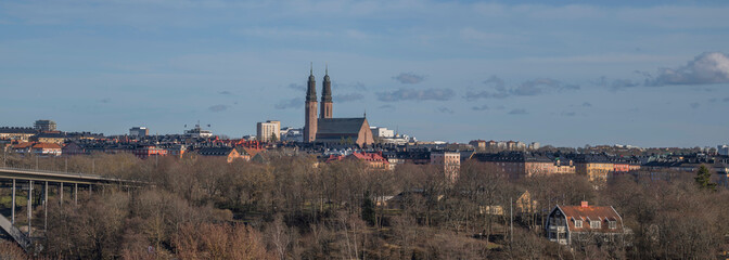 Panorama view over the district Södermalm and old prison island Långholmen and the twin tower church Högalidskyrkan a sunny spring evening in Stockholm - obrazy, fototapety, plakaty