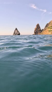 Sea water surface. Low angle view from kayak, camera flies over clear sea water. Nobody. Holiday recreation concept. Abstract nautical summer ocean nature. Slow motion. Close up. Vertical video