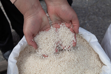 Rice is sold at the market. Hands full of rice - 784358535