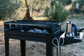 Closeup of a barbecue oven with a kettle on a backyard