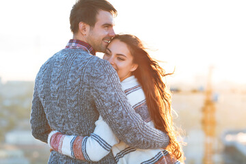 Young man and woman embrace and having fun outdoors