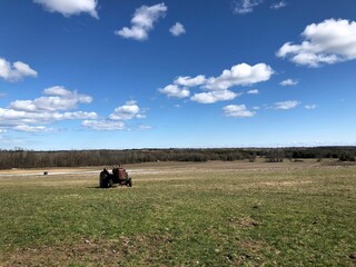 Beautiful landscape of a field with an agricultural machine in th distance.
