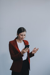 Annoyed angry young woman mad about spam message stuck phone looking at smartphone isolated on...