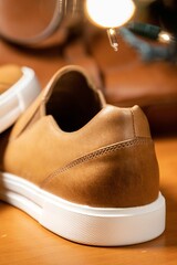 Vertical view from behind of a brown solid slip shoe over the wooden table