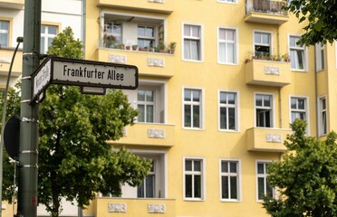 Road sign of Frankfurter Alley on the background of a yellow building in Berlin, Germany