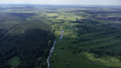 view of the small river in the field and forest from the high