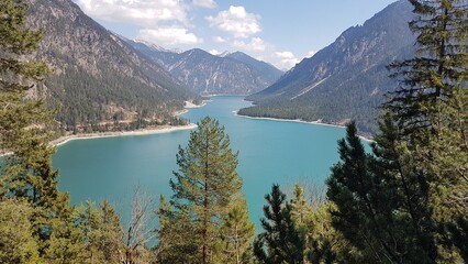 Scenic view of the blue Plansee lake surrounded by mountains in Reutte District, Tyrol, Austria