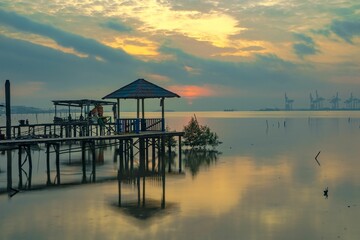 Scenic view of a wooden dock over a calm lake during sunset
