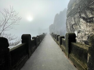 Walkway on Bastei bridge in Switzerland just after sunrise on foggy day