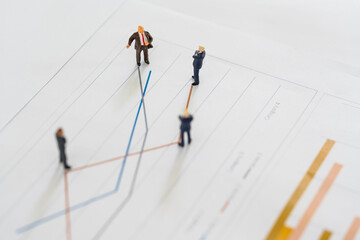 A group of miniature businessman looking at line chart,  review on volatility stock market line graph data report