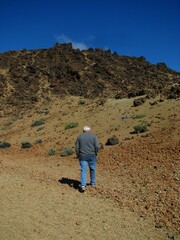 Vertical shot of the man in front of a Teide mountain in Tenerife, Canary Islands, Spain