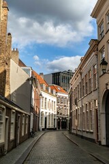 Obraz premium Vertical shot of a narrow street under a cloudy sky