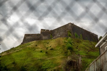 Low-angle view of an old castle on the peak of the mountain.