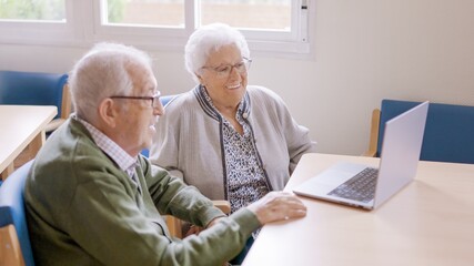 Grandparents smiling during a video call talking to their family